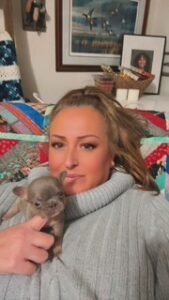 Crissie holding a newborn puppy at home